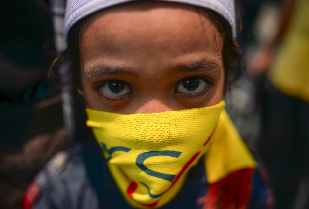 A child using a banner to cover his face looks on as Maria Chin Abdullah (not pictured), chairperson of Bersih -- the coalition of Malaysian NGOs and activist groups -- speaks to journalists after giving statements on the groups that staged the huge August 29 rally, at police headquarters in Kuala Lumpur on September 2, 2015. The organisers of the massive weekend demonstration demanding the Malaysian prime minister's removal over corruption allegations were summoned by police on September, after the government earlier threatened they could face charges. Meanwhile, police said on September 3 that former Malaysian premier Mahathir Mohamad would also be questioned over statements he made at the demonstrations. AFP PHOTO / MOHD RASFAN (Photo credit should read MOHD RASFAN/AFP/Getty Images)